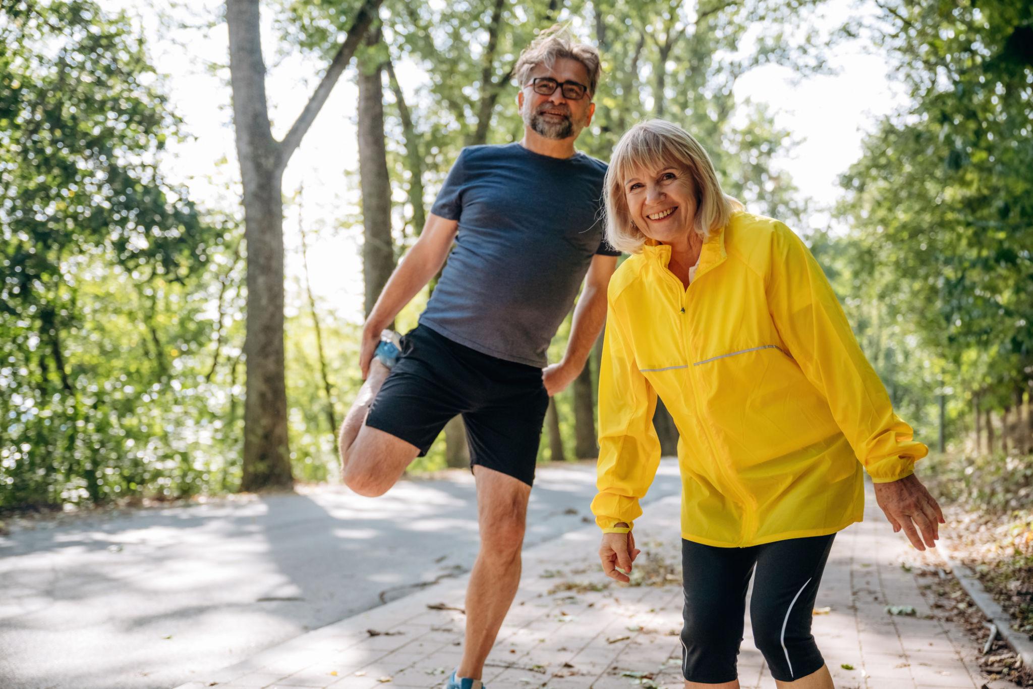 Active senior couple jogging outdoors — representing the freedom and mobility that effective pain management can restore